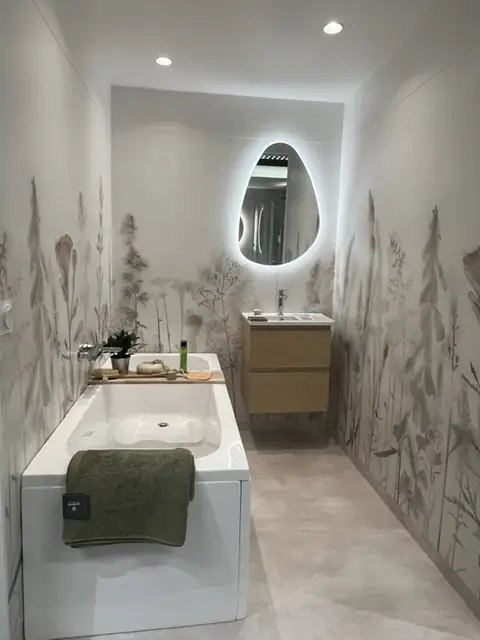 Showroom-badrum med badkar, ekkommod och blommig tapet