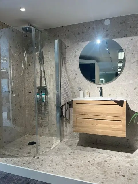 Showroom-badrum med terrazzovägg, ekkommod och walk-in-dusch